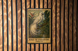 A vintage postage stamp featuring a white bird with long tail feathers, set against a tropical background, is displayed on a wooden wall.