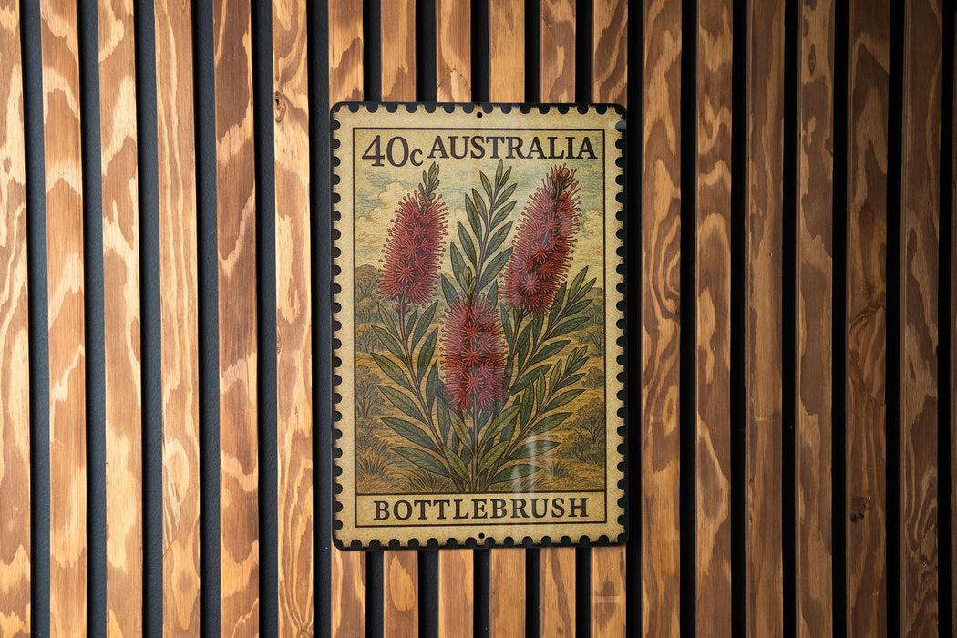 A framed stamp or postcard with a floral design, mounted on a wooden wall.