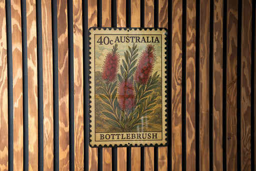 A framed stamp or postcard with a floral design, mounted on a wooden wall.