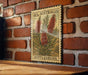 a vintage-style stamp or label with a floral design, mounted on a brick wall.