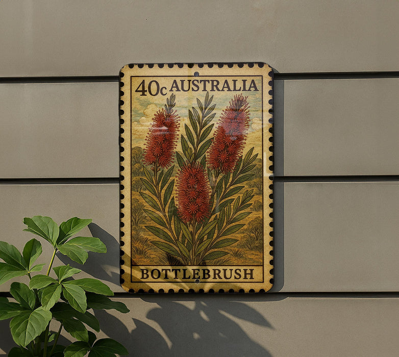 a vintage-style stamp or postcard with a floral design, mounted on a wall next to a plant.