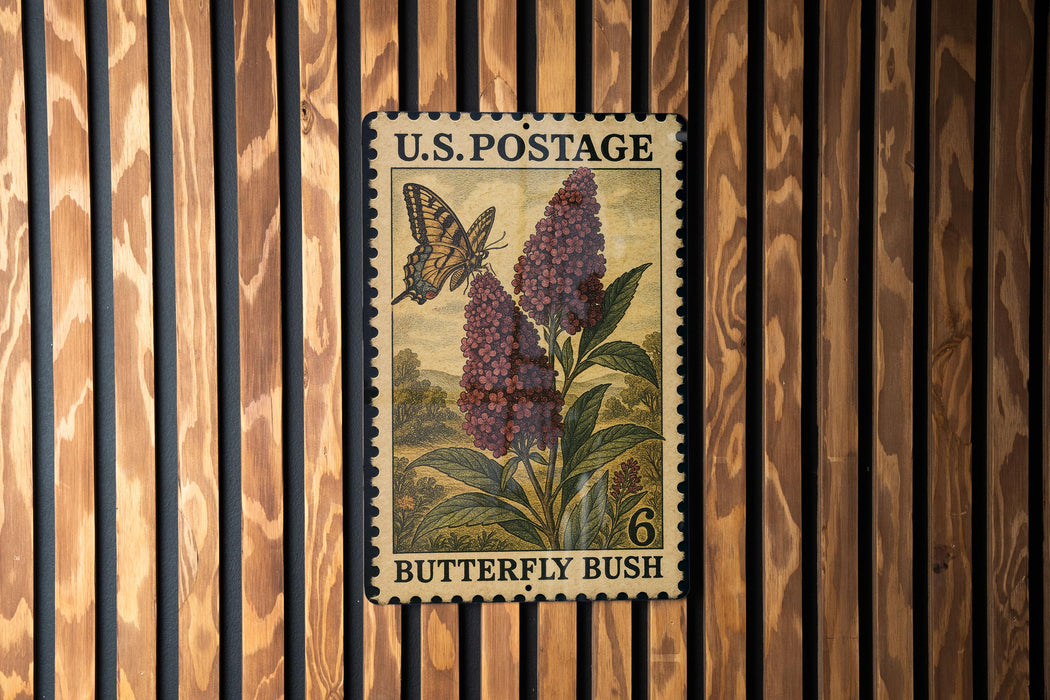 A U.S. postage stamp featuring a butterfly and a flowering bush, mounted on a wooden wall.