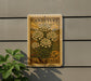 A vintage-style U.S. postage stamp featuring a floral design is mounted on a gray wall, with a small green plant to the left.