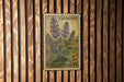 A vintage postage stamp featuring a depiction of purple flowers, mounted on a wooden wall.