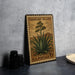 A vintage U.S. postage stamp featuring an illustration of an agave plant, placed on a dark surface next to some black camera lenses.