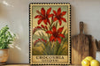 a framed illustration of red crocuses (Lucifer) on a shelf, with a wooden cutting board and a potted plant nearby.
