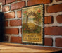A metal sign with a decorative design hangs on a brick wall, featuring a crown of thorns and flowers.