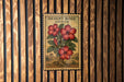A vintage-style poster of a desert rose adenium is displayed on a wooden wall.