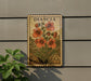 A vintage postage stamp featuring a floral design is displayed on a wall, with a plant visible to the left.
