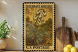 A vintage postage stamp featuring a floral design, placed on a shelf next to a wooden cutting board and some potted plants.