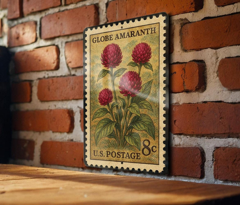 A vintage-style postage stamp featuring a red flower on a brick wall.