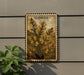 a framed illustration of a plant with yellow flowers, mounted on a wall next to a plant.