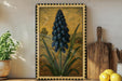 a framed illustration of a blue flower with green leaves, placed on a shelf next to a wooden cutting board and a potted plant.
