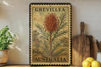 a vintage postage stamp from Australia, with a large illustration of a plant on it, placed on a shelf next to a wooden cutting board and some potted plants.