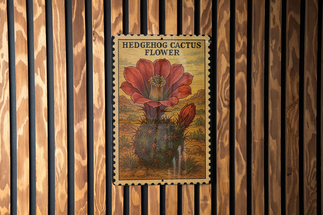 A vintage-style postage stamp featuring a detailed illustration of a red-flowered hedgehog cactus flower is displayed on a wooden wall.