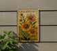 A wooden sign with a floral design and the word "HELENIUM" printed on it, mounted on a wall next to a plant.