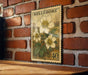 A vintage-style postage stamp featuring a floral design is displayed on a brick wall.