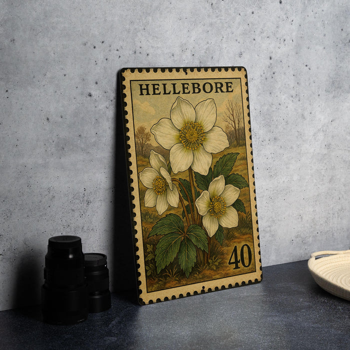 A metal stamp with a floral design and the number 40 on it, placed on a countertop next to some black camera lenses.