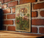 A vintage-style stamp featuring a floral illustration of honeysuckle flowers is displayed on a brick wall.