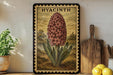 A framed illustration of a hyacinth flower is displayed on a shelf, accompanied by a wooden cutting board, a potted plant, and a lemon.