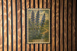 A framed illustration of blue flowers is hanging on a wooden wall.