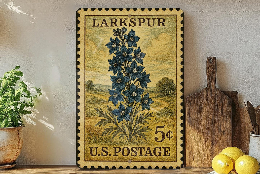 A vintage-style postage stamp from Larkspur, featuring a blue flower illustration, is displayed on a shelf next to a wooden cutting board and some kitchen utensils.