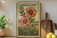 A framed illustration of two red flowers on a green background, with the word "MALLOW" written above them, is displayed on a shelf next to a wooden cutting board and a potted plant.