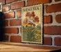 A vintage-style postage stamp featuring a floral design is displayed on a brick wall.