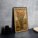 A metal stamp with a desert plant illustration and text, placed on a countertop next to some black camera lenses.