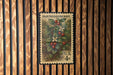A vintage postage stamp featuring a detailed illustration of a berry plant with red berries and white flowers, mounted on a wooden wall.