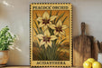 A framed illustration of a peacock orchid plant with yellow flowers, placed on a shelf next to a wooden cutting board and a potted plant.