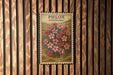 A framed illustration of a flower is hanging on a wooden wall.