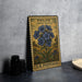 A vintage postage stamp featuring a blue wild blue flower, placed on a gray countertop next to some black camera lenses.