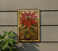 a large, vibrant red poinsettia flower with green leaves, displayed on a wall.