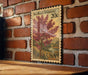 A vintage-style postage stamp featuring a tree with pink flowers, mounted on a brick wall.