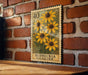 A vintage postage stamp featuring a vibrant illustration of yellow sunflowers is displayed on a brick wall.