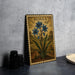 a framed illustration of blue flowers on a wall, with a vintage-style border.