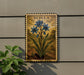 a decorative metal plaque with a floral illustration of blue flowers, mounted on a wall next to a plant.