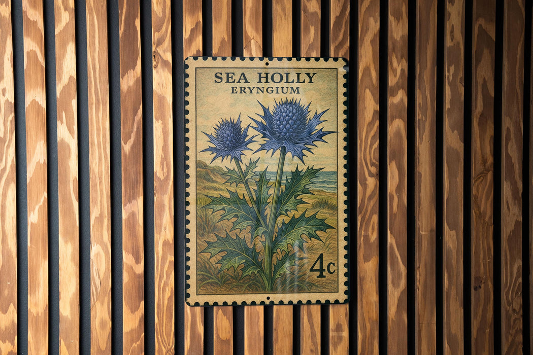A vintage postage stamp from Sea Holly Eryngium, featuring a blue flower with green leaves, is displayed on a wooden wall.