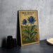 A metal stamp featuring a blue thistle flower and the text "SEA HOLLY ERYNGIUM" is displayed on a table.