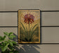 a decorative floral artwork with a vibrant red flower and green leaves, displayed on a wall.
