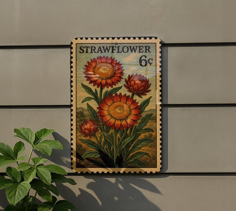 a stamp-like artwork depicting a vibrant red flower with green leaves, mounted on a wall.