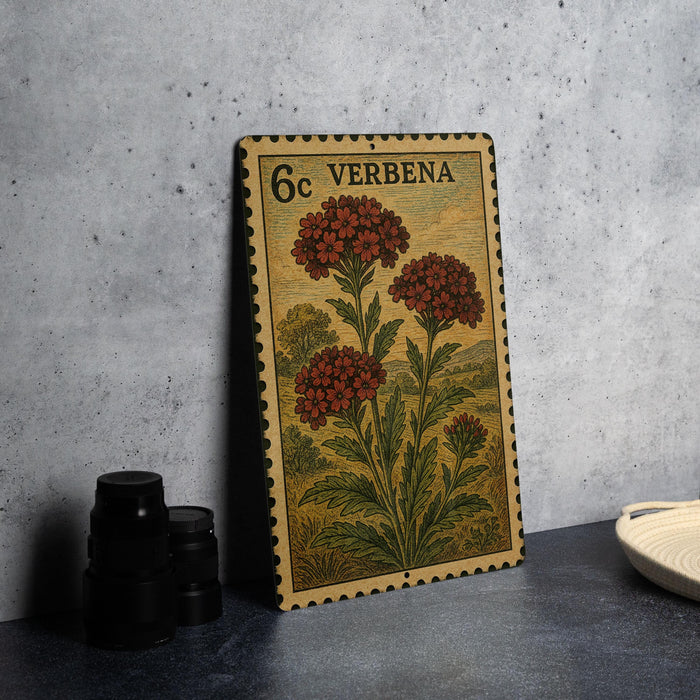 A vintage postage stamp featuring a floral design is displayed on a table, accompanied by a stack of black camera lenses and a white dish.
