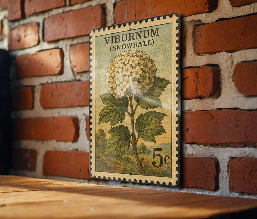 A vintage postage stamp featuring a snowball plant is displayed on a brick wall.