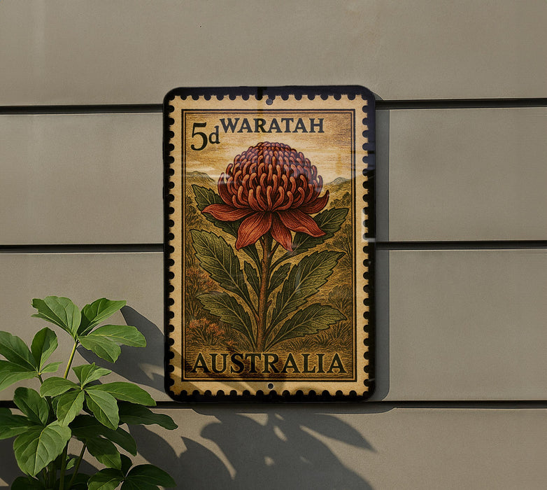A 5d Waratah postage stamp from Australia is displayed on a wall, with a plant to the left of the stamp.