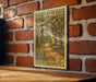 A vintage-style postage stamp depicting a scenic road through a lush, wooded area, mounted on a brick wall.