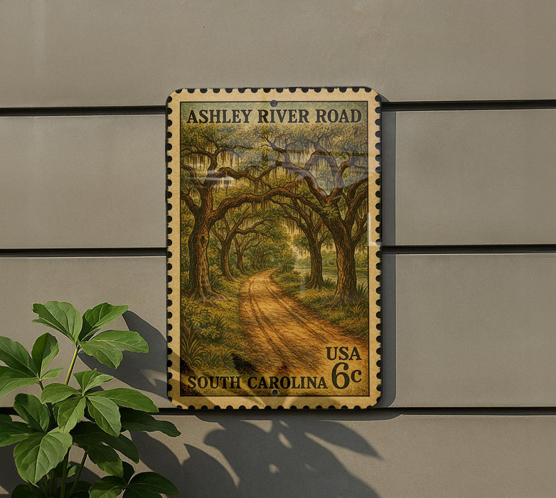 A vintage-style postage stamp depicting a scenic road lined with trees, mounted on a wall next to a plant.