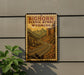 A vintage-style sign for the Bighorn Scenic Byway in Wyoming, featuring a winding road surrounded by mountains and trees.