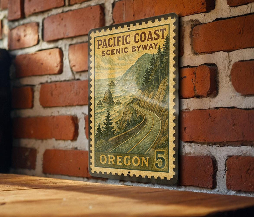 A vintage-style postage stamp from Oregon, featuring a scenic coastal landscape with mountains, trees, and a winding road.