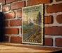 A vintage-style postage stamp depicting the Pyramid Lake scenic byway in Nevada, hanging on a brick wall.